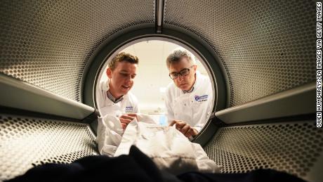 PHD student Max Kelly, 24 and marine microbiologist Professor J Grant Burgess both from Newcastle University check clothing in a washing machine at the Benton Proctor and Gamble site in Newcastle, during research into the release of microfibres using different washing cycles. (Photo by Owen Humphreys/PA Images via Getty Images)